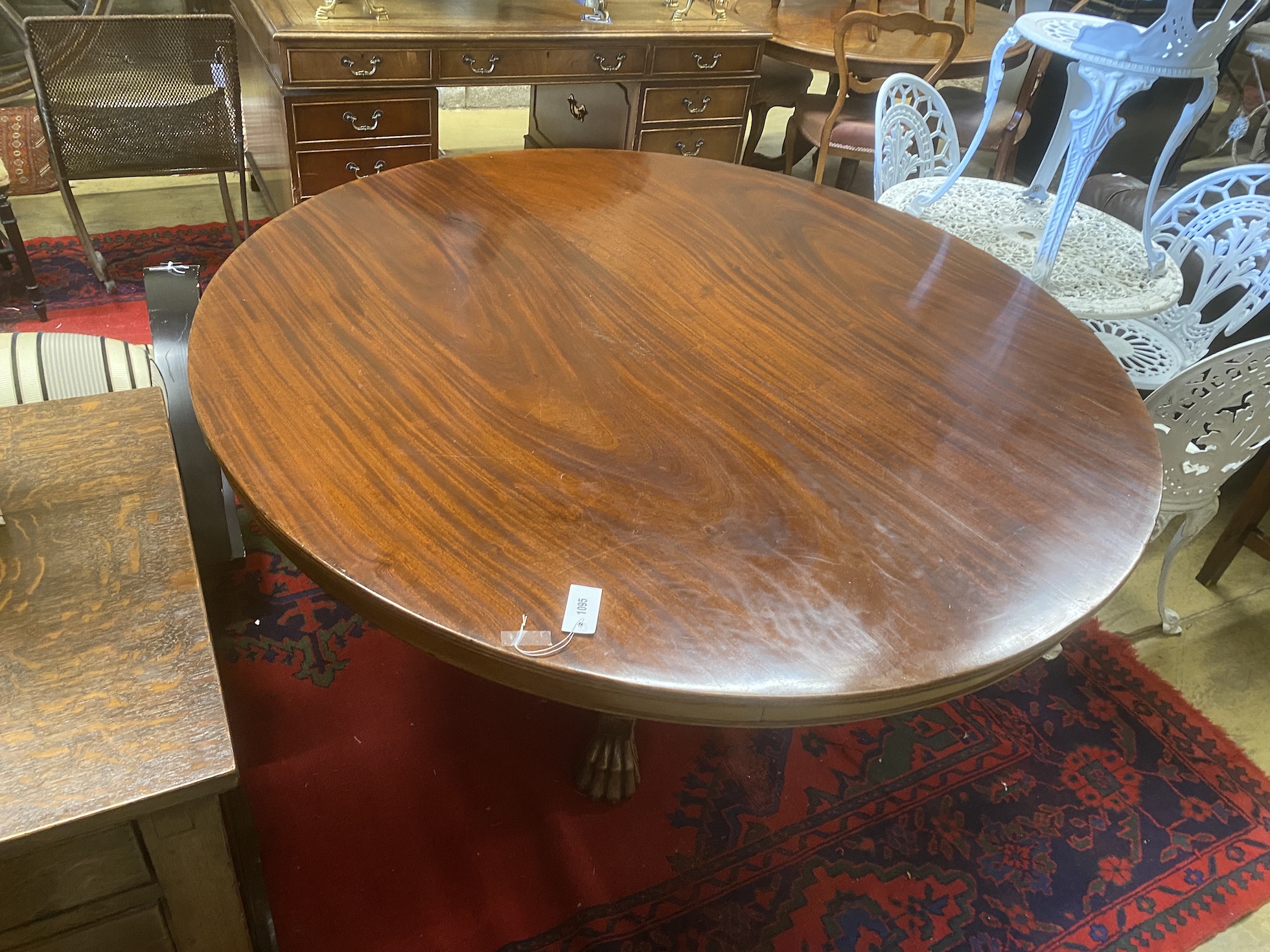 A WIlliam IV circular mahogany tilt top breakfast table on fluted column and lion's paw feet, diameter 145cm, height 76cm